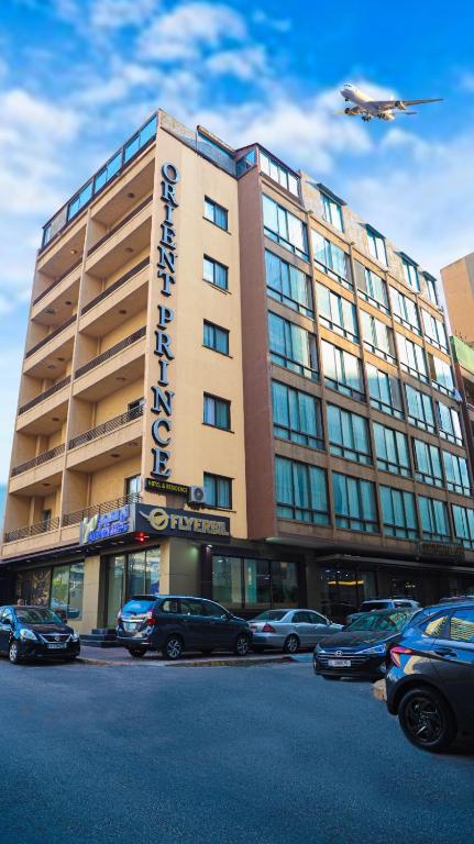 a large building with an airplane flying over it at Orient Prince Hotel in Beirut