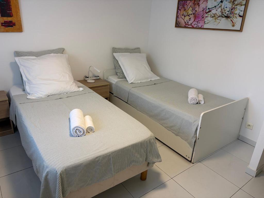 two beds in a room with white sheets at Chez-Sonia chambre 1 in Rosny-sous-Bois