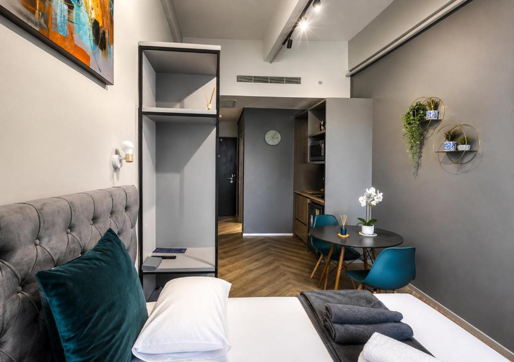 a bedroom with a bed and a table and chairs at One Thibault Hotel - Sea View Studio - Near CTICC & V&A Waterfront in Cape Town