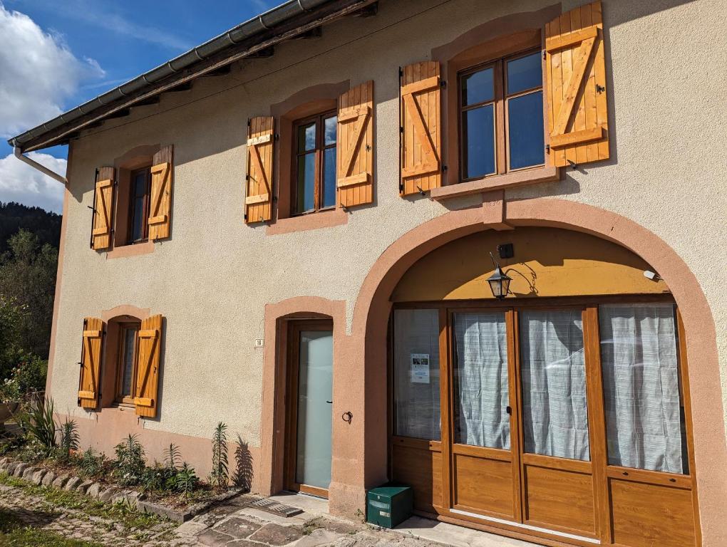 a house with wooden doors and a balcony at Chambre Jonquille in Rehaupal