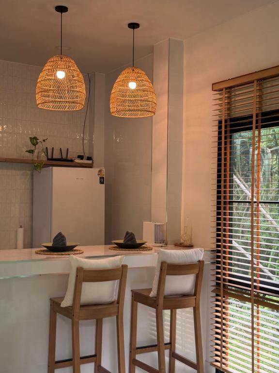 a kitchen with two bar stools and two lights at Moon & Banana in Ko Phangan