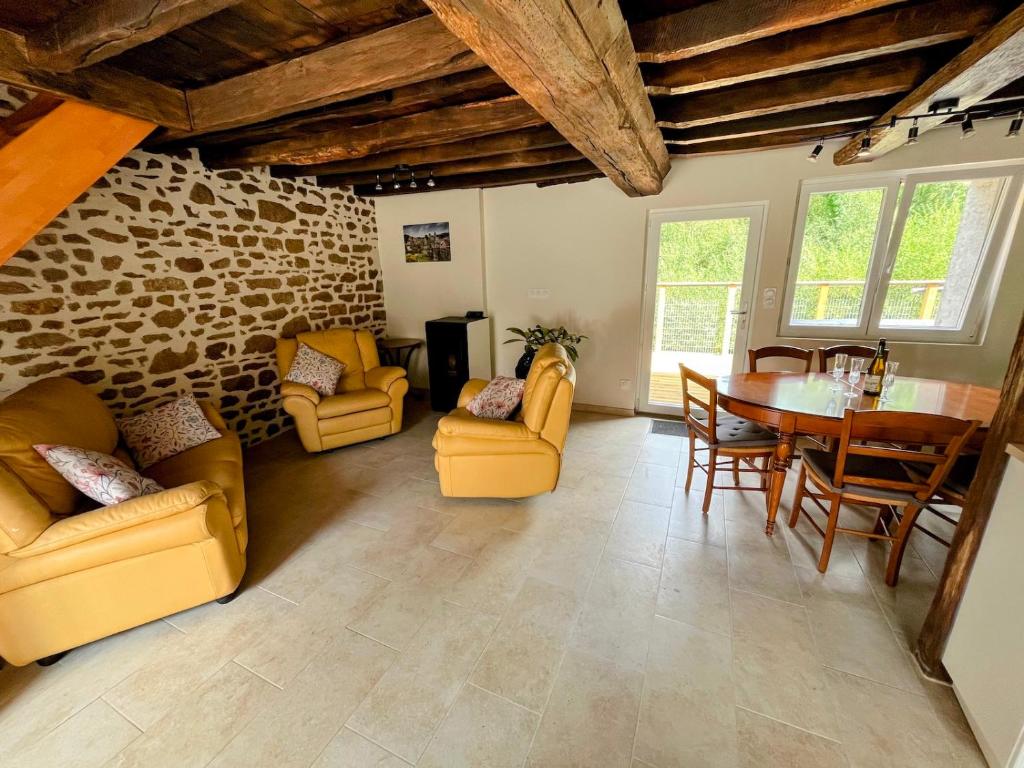 a living room with yellow furniture and a table at Maison de vacances proche de Pontmain in Saint-Mars-sur-la-Futaie