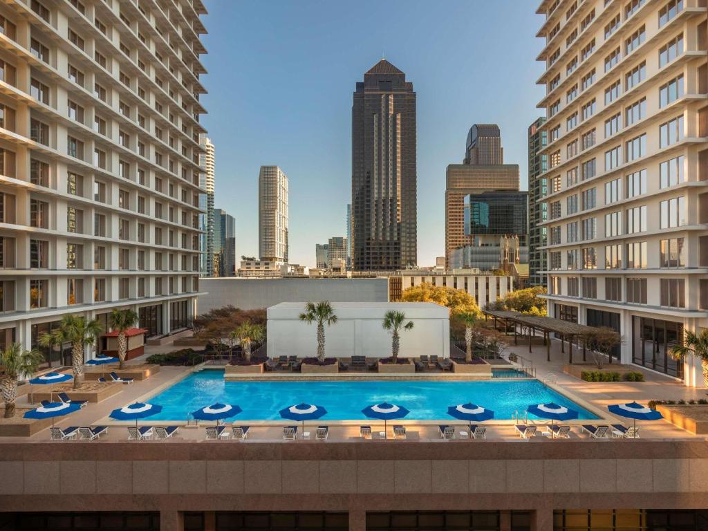 a pool in the middle of a city with tall buildings at Fairmont Dallas in Dallas