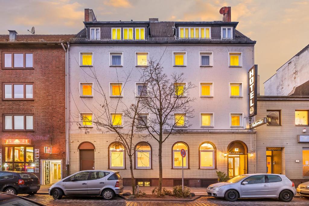 ein großes weißes Gebäude mit davor geparkt in der Unterkunft Signature Hotel Astoria in Hamburg