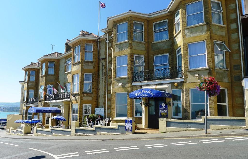 um grande edifício com guarda-chuvas azuis em frente em Royal Pier em Sandown