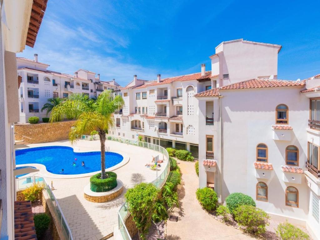 an apartment with a swimming pool and buildings at Renteando Albir Apartments in Albir
