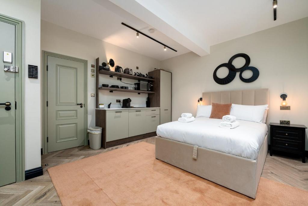 a bedroom with a large bed and a kitchen at GuestReady - The Euston in London