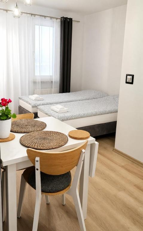 a room with two beds and a table and chairs at Route66 apartament by Karl Clim&Park in Radom