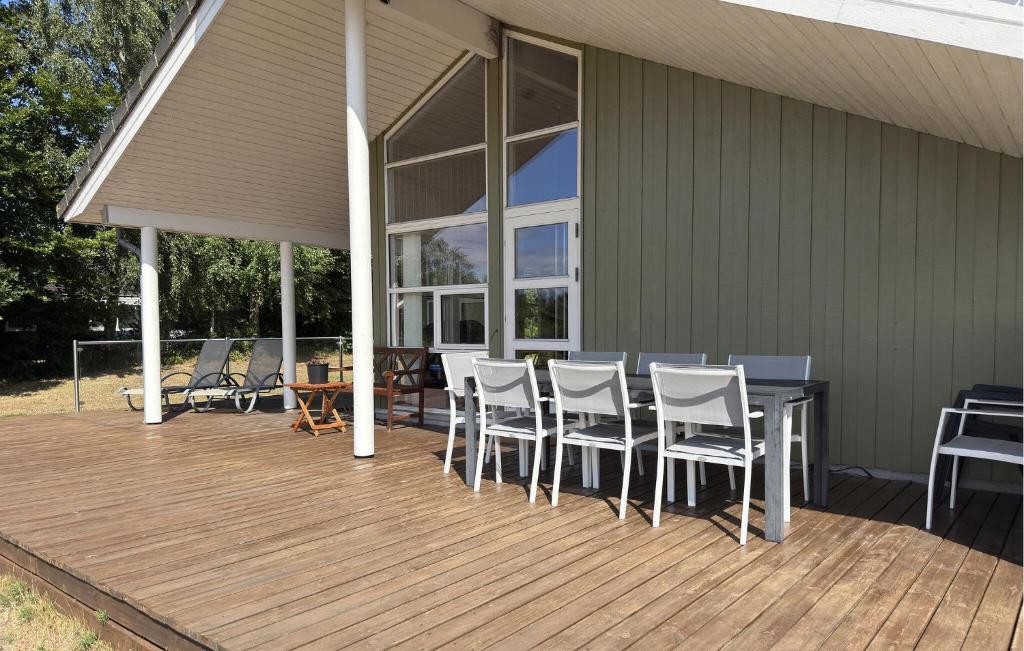 a wooden deck with a table and chairs on a house at Nice Home In Grenaa With Sauna in Grenå