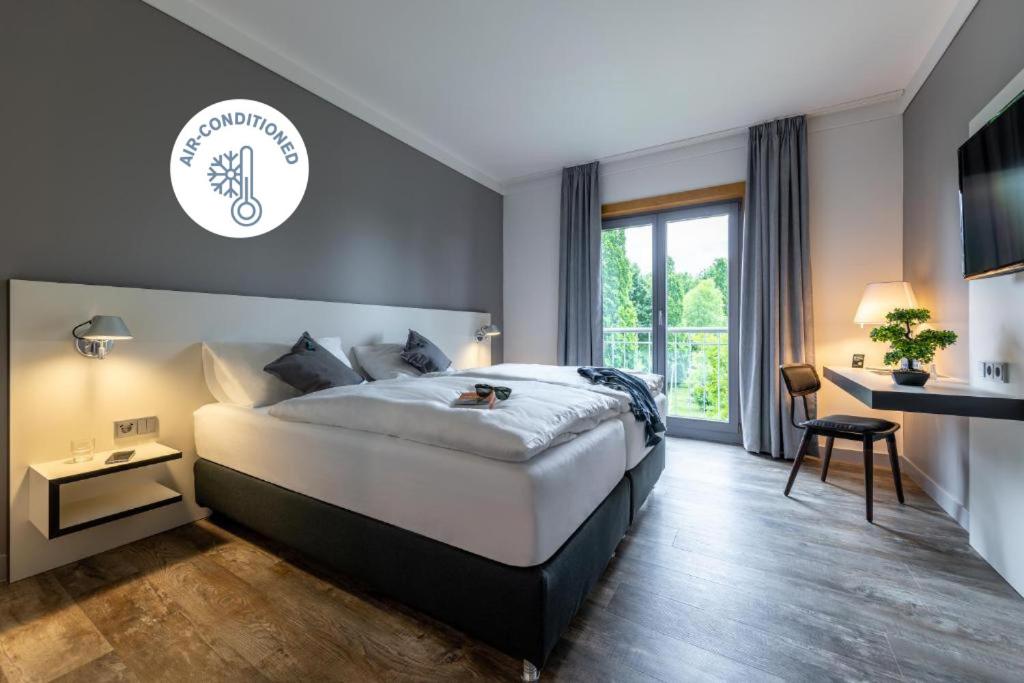 a hotel room with a large bed and a window at Coffee Fellows Hotel Leipheim Süd in Leipheim