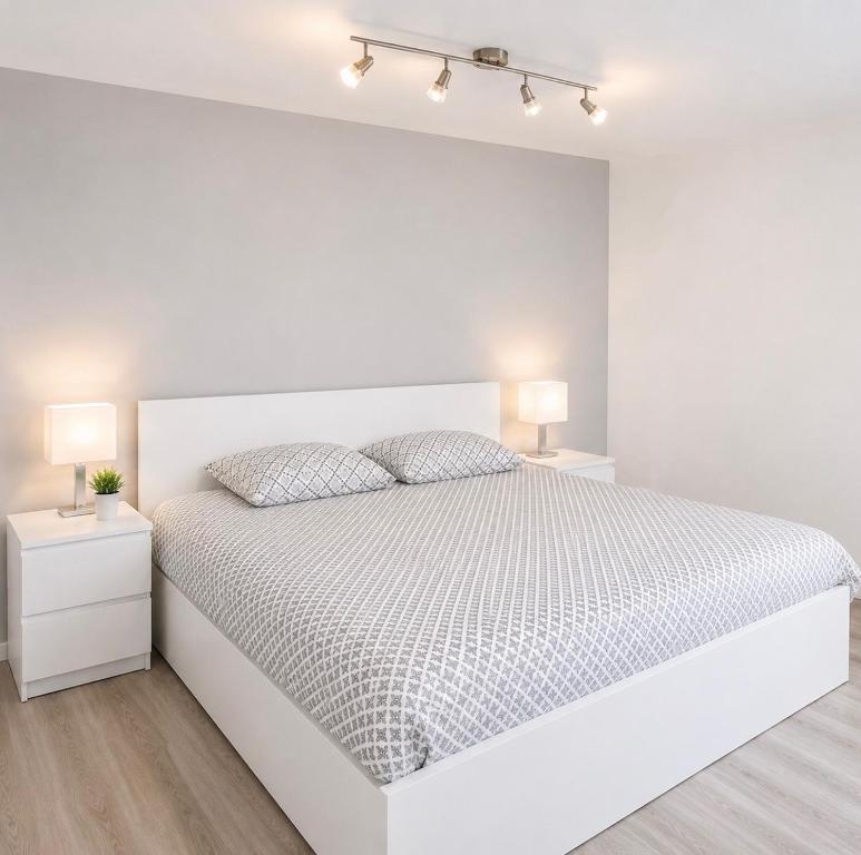 a white bedroom with a white bed and two night stands at Cozy Apartment with Terrace & Free Parking in Würzburg