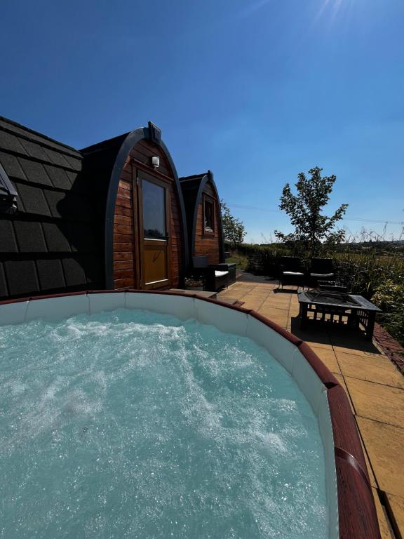 a luxury igloo house with a hot tub in the backyard at Rabbit Glamping Pod in Leighton