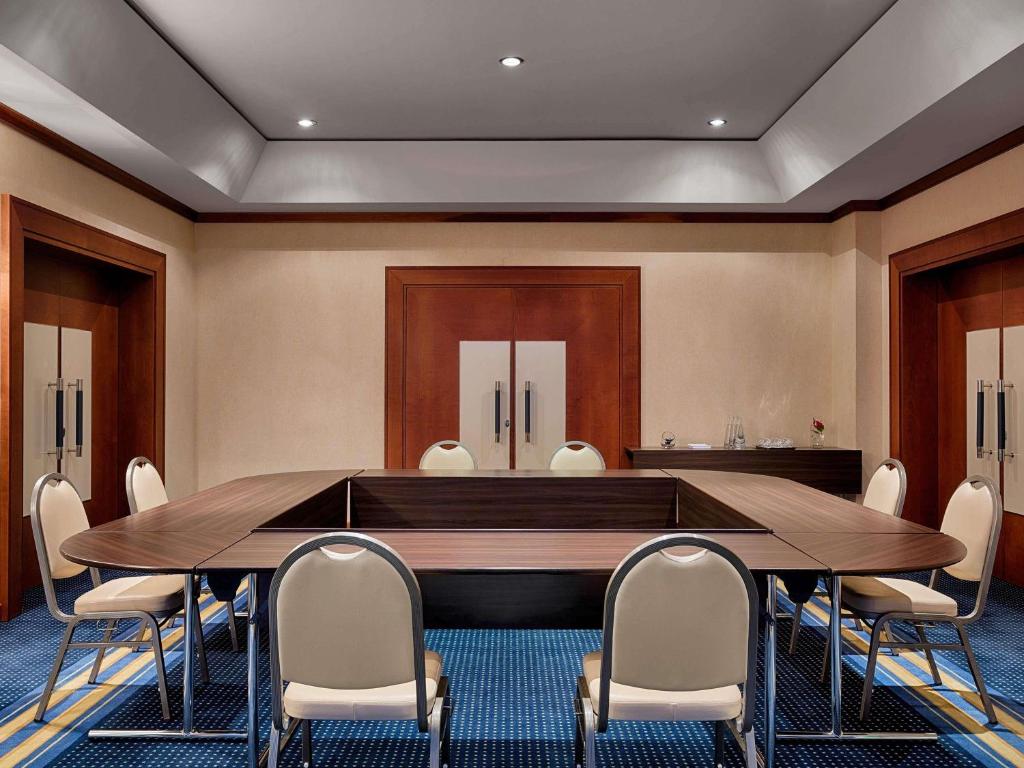 a conference room with a large wooden table and chairs at Hotel Oran Bay Managed By Accor in Oran