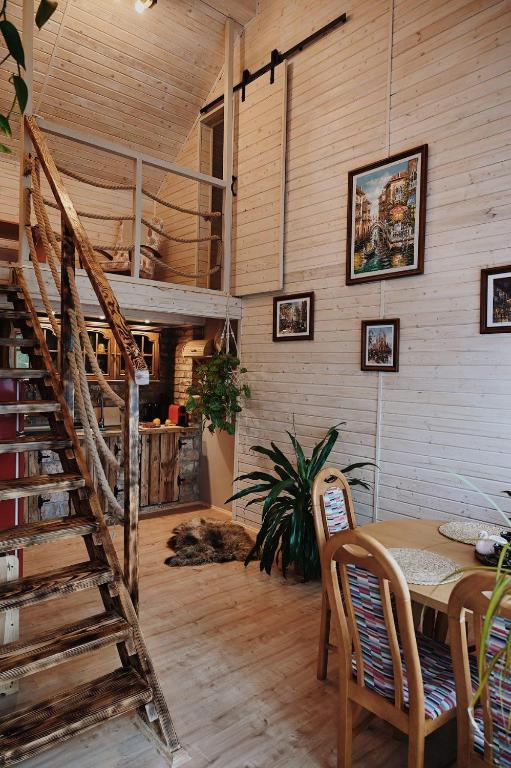 a dining room with a table and a staircase at Domek na wyłączność w Otulinie Ojcowskiego Parku Narodowego in Wola Kalinowska