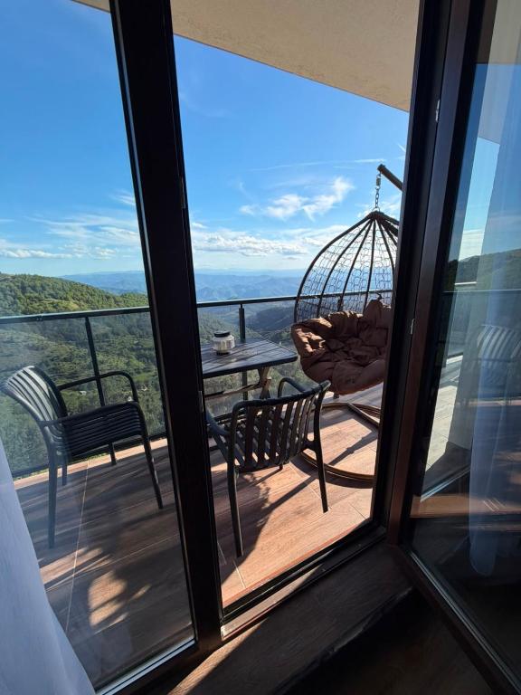 a balcony with a swing and a table and chairs at Black Elegant & Spa Kop in Kopaonik