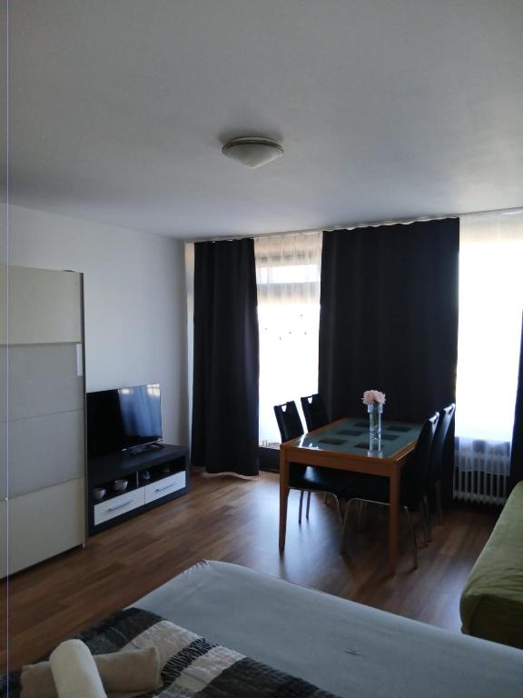 a living room with a dining table and a television at B1011, gemütliches Appartement mit Ausblick in Lahnstein