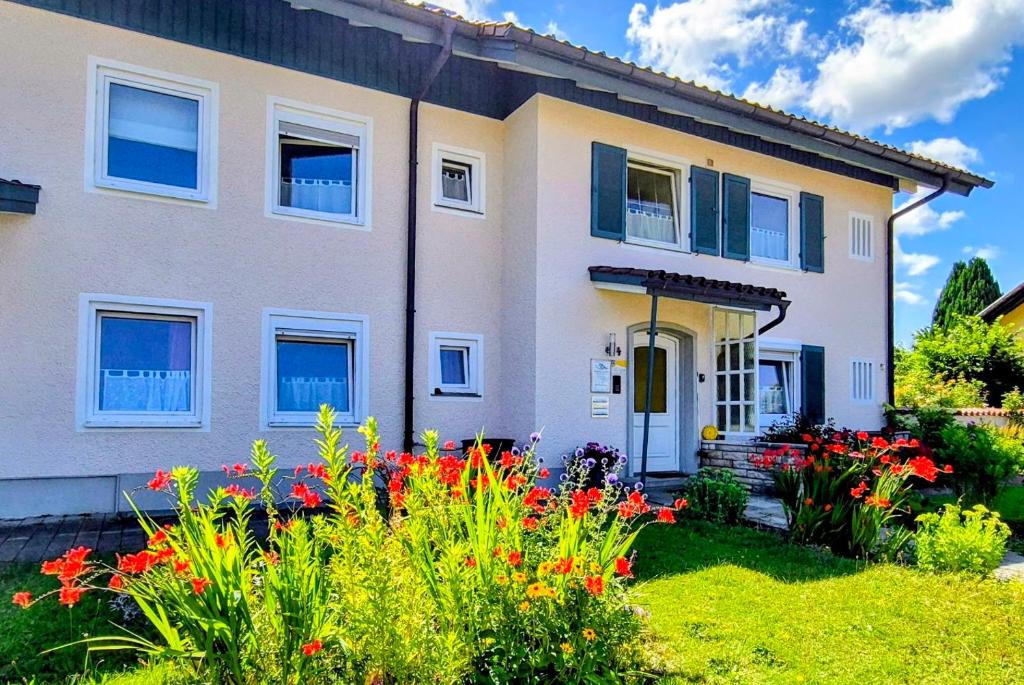 a house with flowers in front of it at Ferienwohnung Pickenhan in Scheidegg