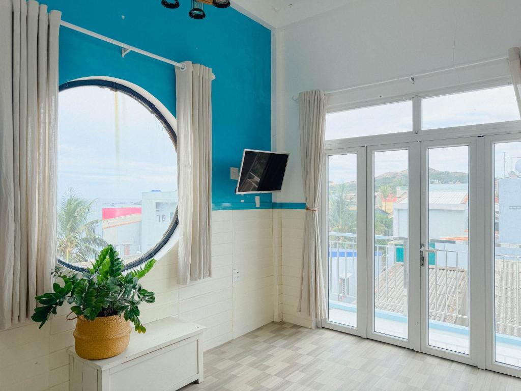 a room with a large window and a potted plant at Gió Home Nhon Ly in Quy Nhon
