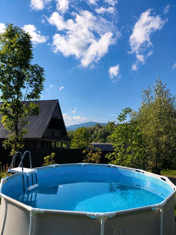 a large blue swimming pool in a yard at Садиба для відпочинку in Vyshka