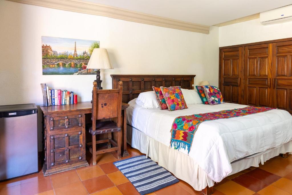 a bedroom with a bed and a desk and a television at Collection O Casa Bella Hotel Boutique, Cabo San Lucas in Cabo San Lucas