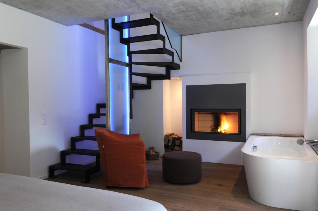 um quarto com uma escada em espiral e uma lareira em MyVerzasca Resort Casa Rossa em Brione