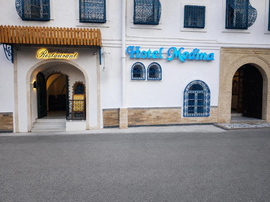 a building with a sign for a store at Hôtel Medina in Sousse