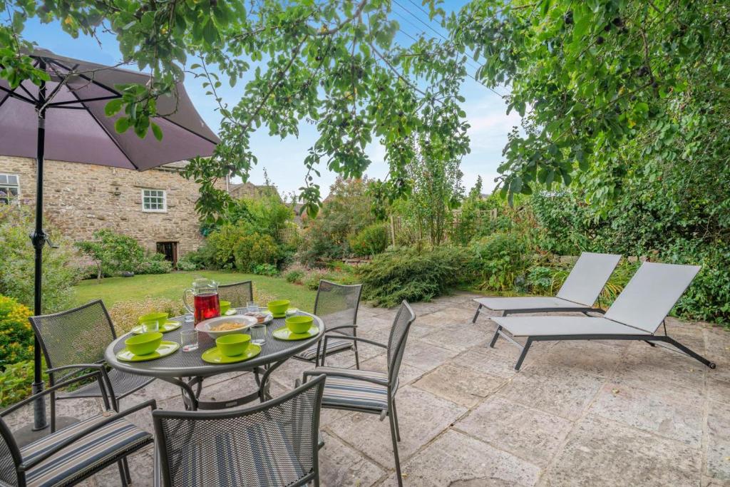 a patio with a table and chairs and an umbrella at 3 Bed in Askrigg oc-ds779 in Askrigg