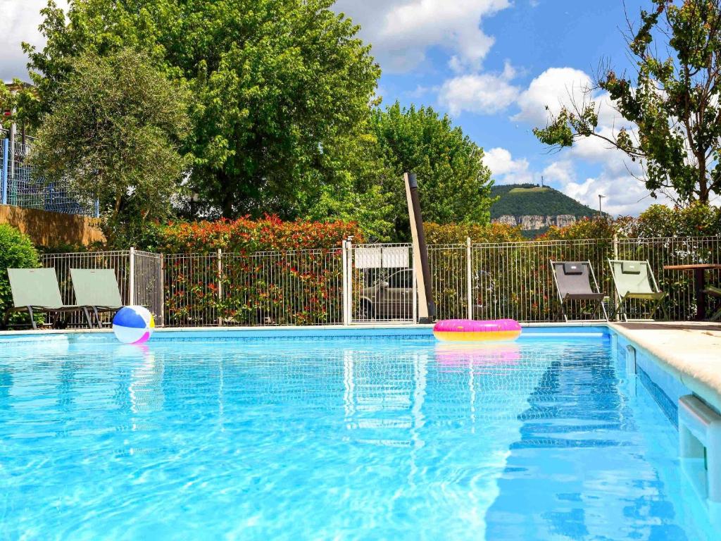 a swimming pool with two frisbees in the water at ibis Budget Millau Viaduc in Millau