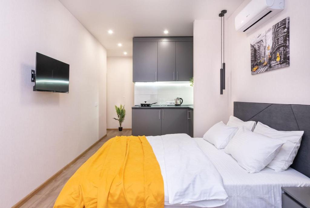 a bedroom with a bed with a yellow blanket on it at Видові Апарти на Озеро поруч з метро Позняки Харківська Ревуцького in Kyiv