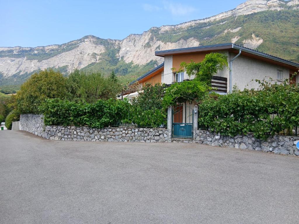 a house with a stone fence and a stone wall at Gîte du Manival in Saint-Ismier