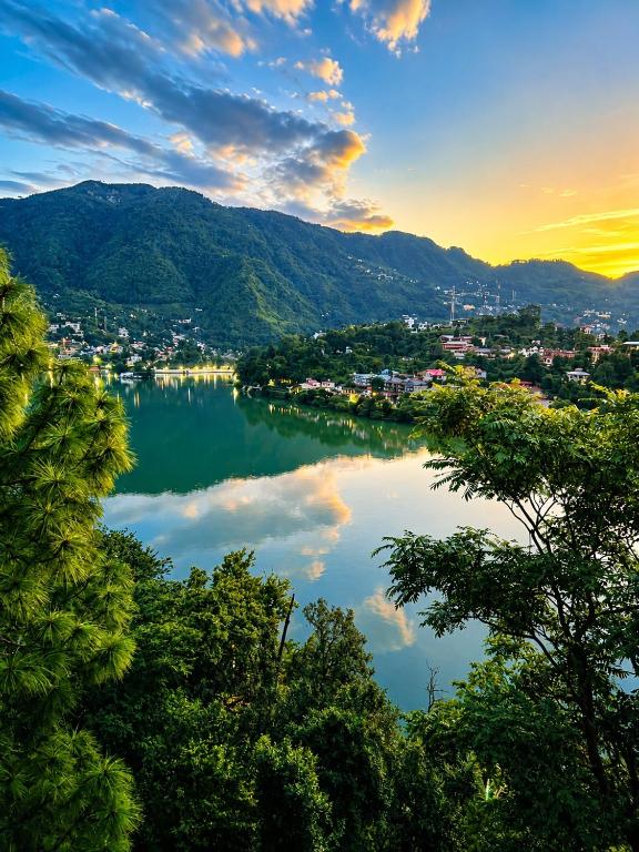 a view of a lake with a city and mountains at The Palace by Boho Travelista in Bhīm Tāl
