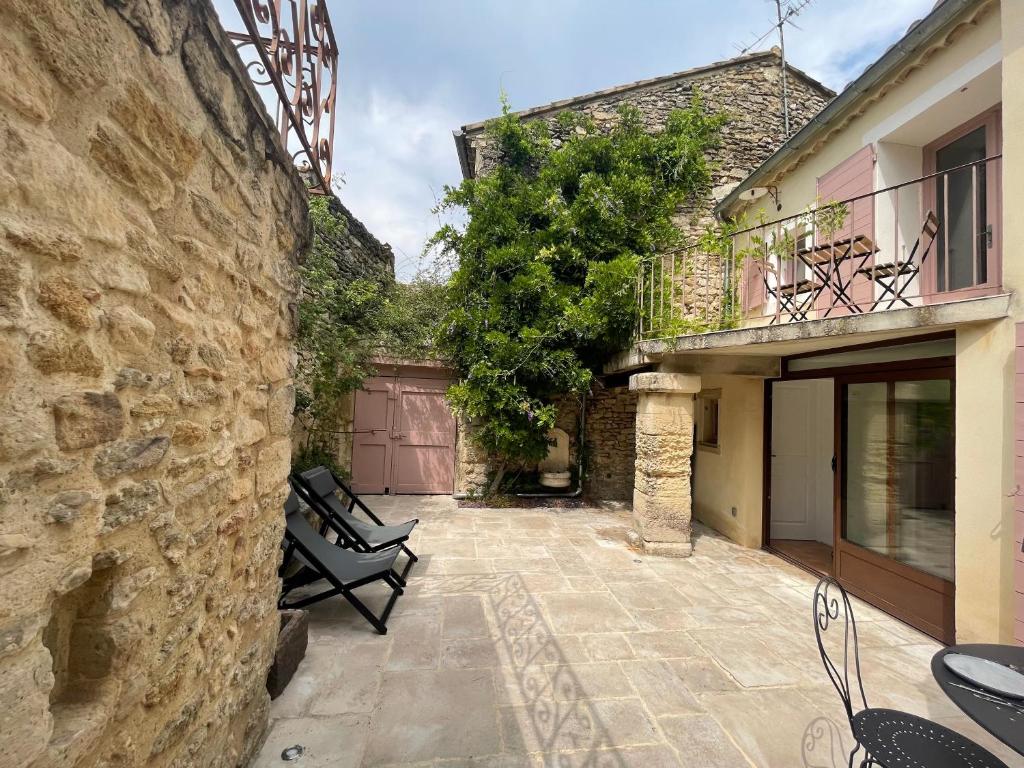 a stone house with a courtyard with a bench at Chez Marie in Grignan