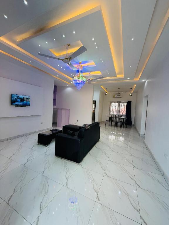 a living room with a couch and a chandelier at Pebview 2 Bed Apartment in Kpone