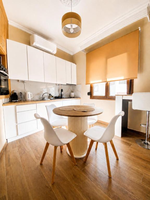 a kitchen with a table and two white chairs at Bright and central apartment in Siátista