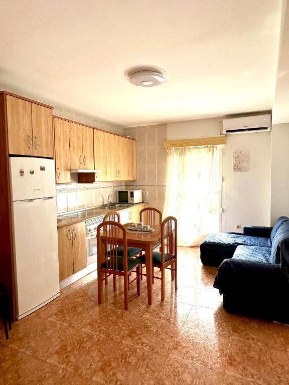 a kitchen with a table and chairs and a couch at Apartamento 1 minuto del mar in El Pozo del Esparto