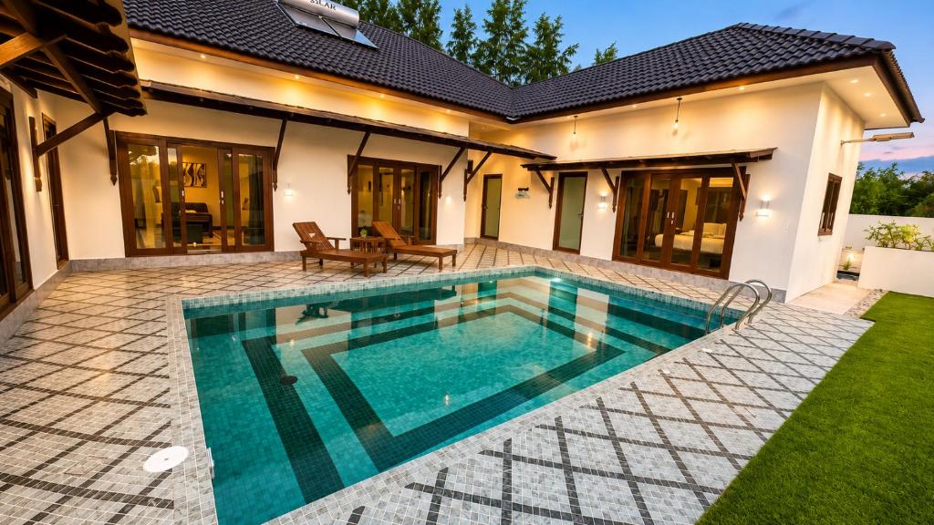 a swimming pool in the backyard of a house at Charis Tanjong Jara Villa Emerald in Dungun