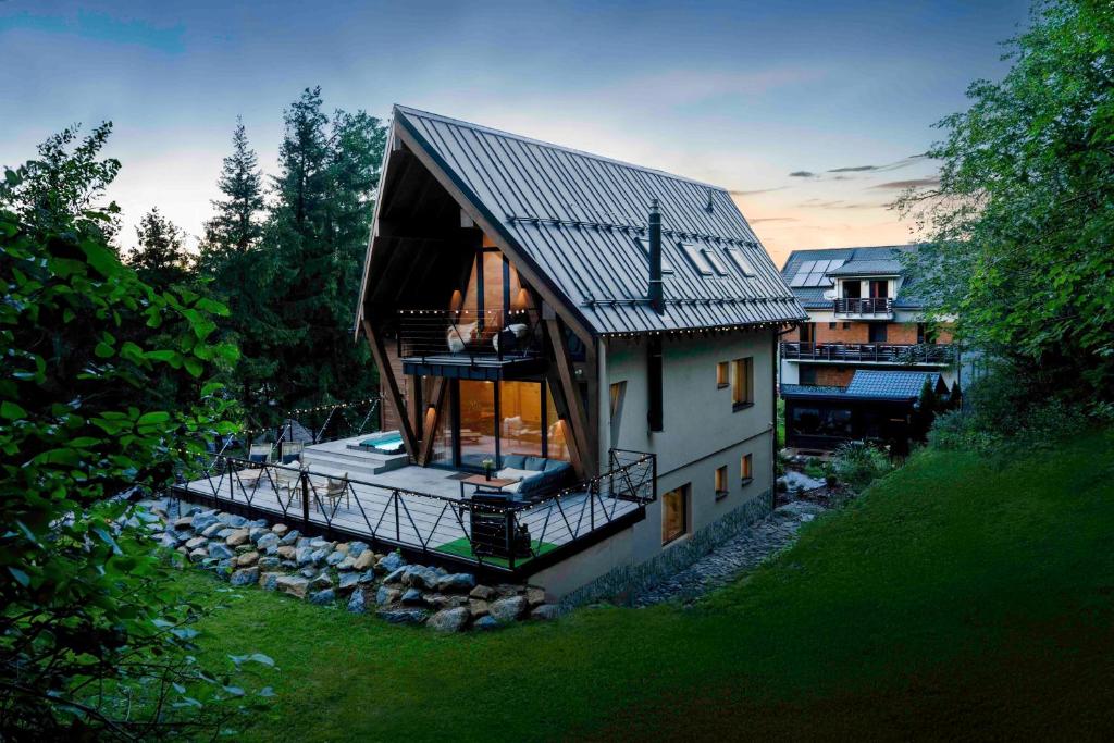 a small house with a gambrel roof and a balcony at Chalet Vista Biohacking & Jacuzzi Recovery Chalet in Belá