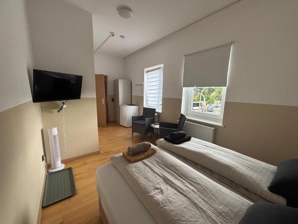 a bedroom with two beds and a flat screen tv at Zimmer für 2 Personen-Bad-Kühlschrank-TV-11 in Meine