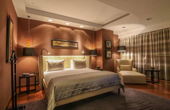 a bedroom with a large bed and a chair at A urassi an HTT hotel in Isly