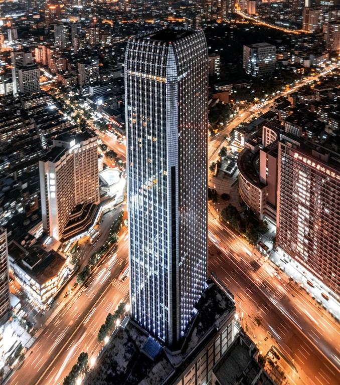 a tall skyscraper in a city at night at High Clouds Hotel Apartment in Guangzhou
