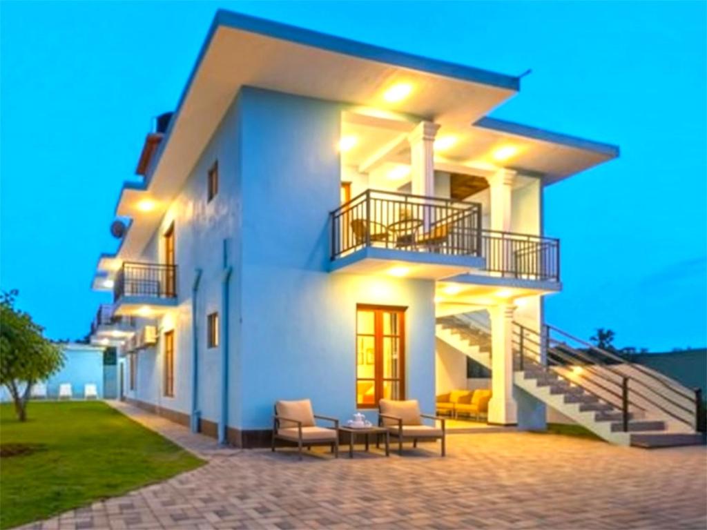 a white house with chairs and a table at New Aqua Glory in Negombo