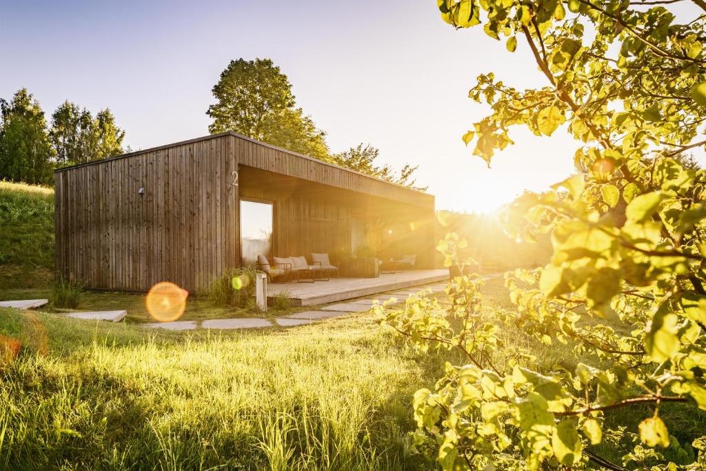 a wooden house in the middle of a field at Wakepond atostogų slėnis in Anykščiai