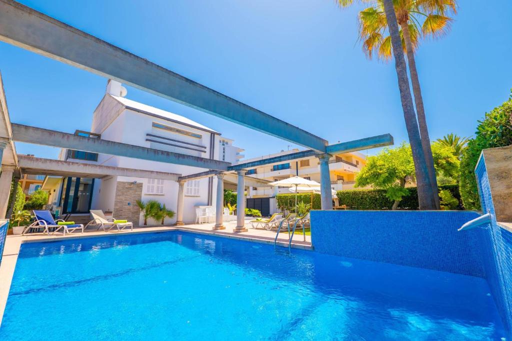 a swimming pool in a villa with a palm tree at Estrel in Can Picafort