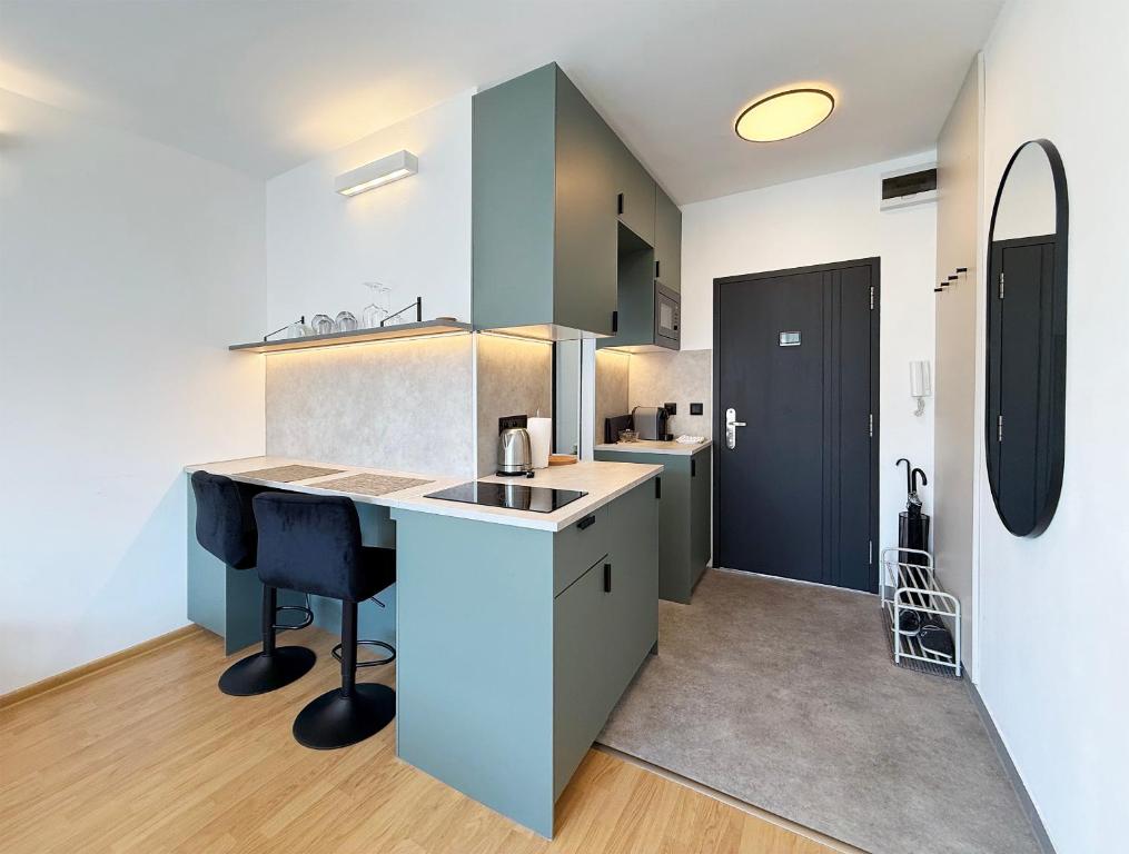 a kitchen with a counter and some chairs in it at Cozy Emerald Studio Bratislava in Bratislava