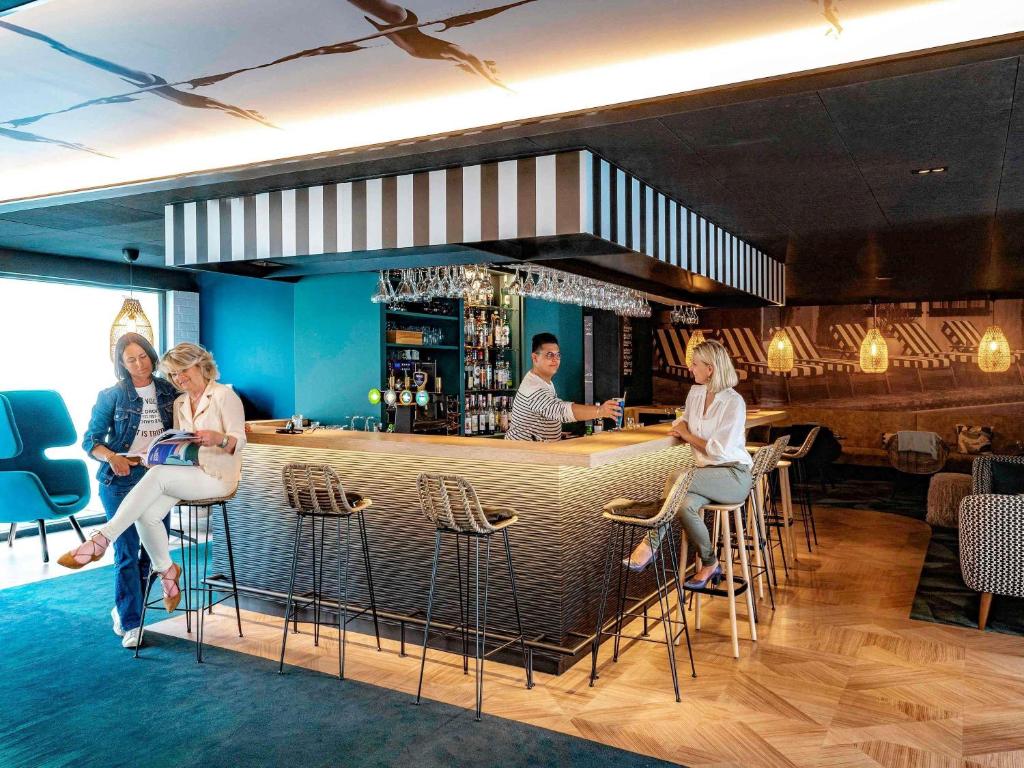 a group of women sitting at a bar at Novotel Lens Noyelles in Noyelles-Godault