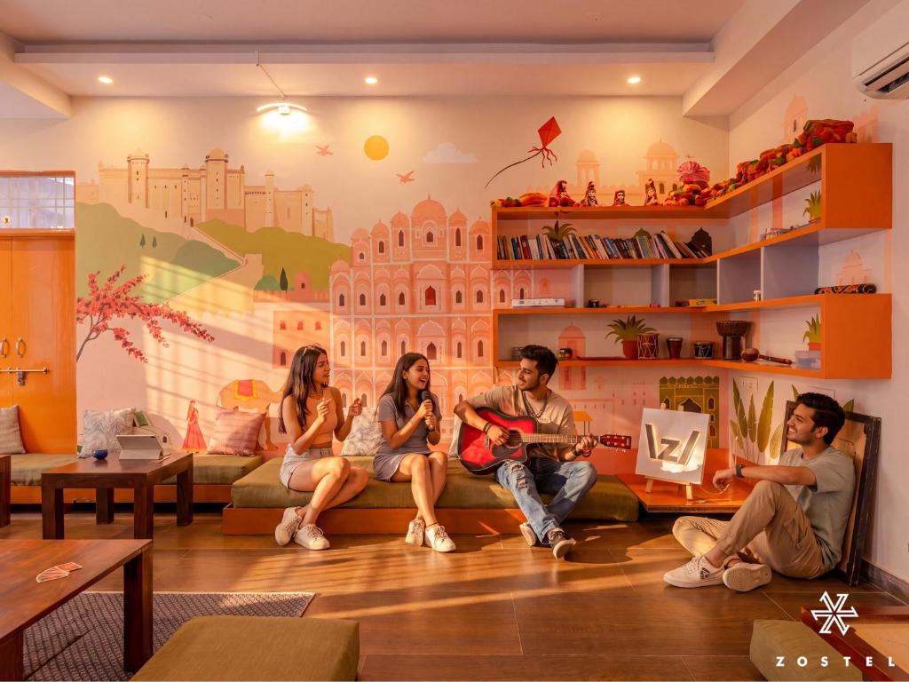 a group of people sitting on a couch in a living room at Zostel Jaipur in Jaipur