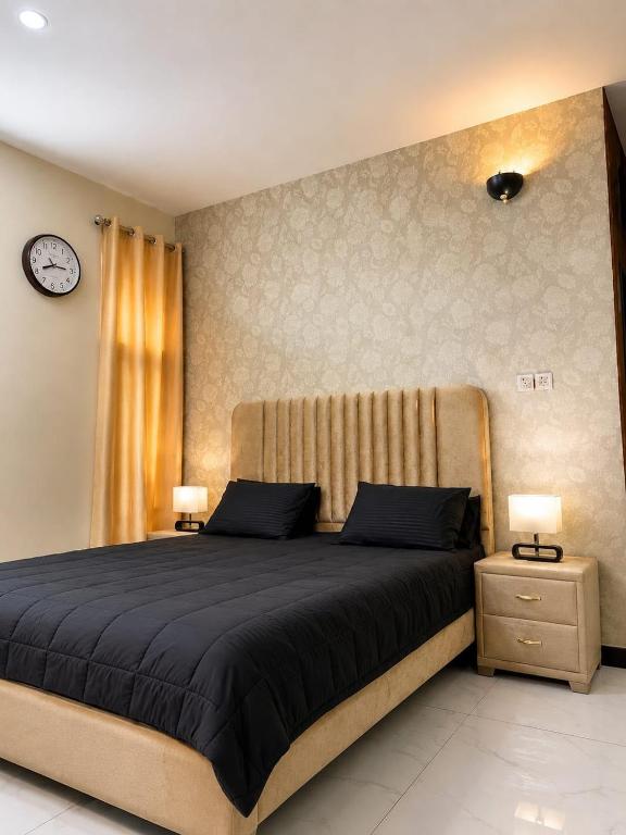 a bedroom with a large bed and two night stands at 6Bedroom Villa DHA Lahore in Lahore