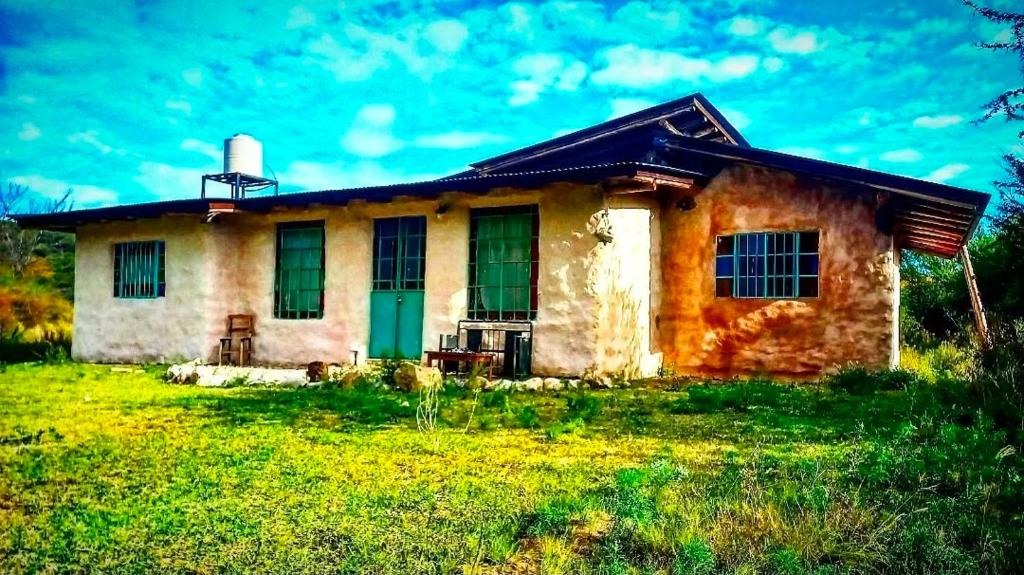a small house with a green door in a field at Kamiare in San Esteban