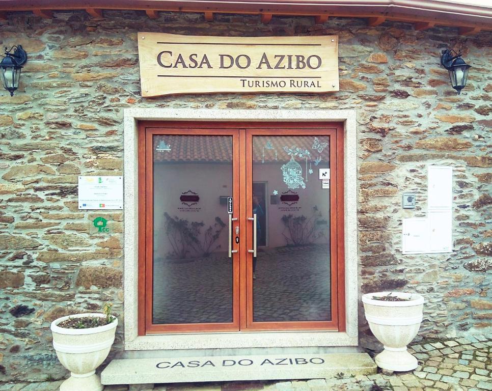 a stone building with a glass door in front at Casa do Azibo in Santa Combinha