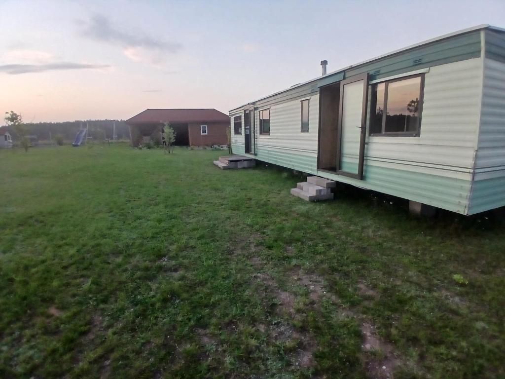 a green and white trailer in a field at DanowskieCamp in Danowskie